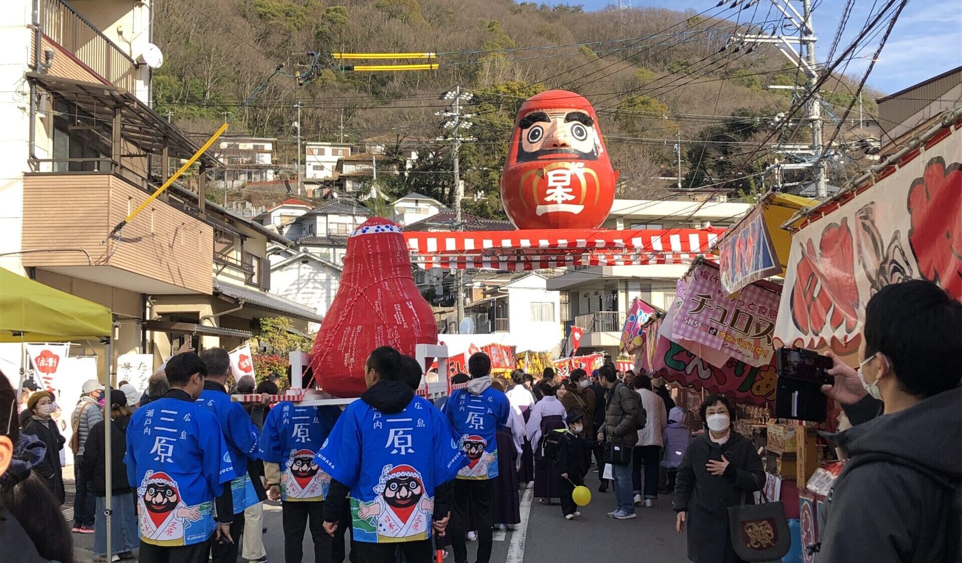 赤いだるまとハッピ姿の人